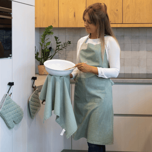 Sage grönt köksförkläde i bomull på kvinna med kökshandduk i ögla
