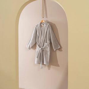 Beige badrock med pebble-struktur hängande i vit båge - lifestyle