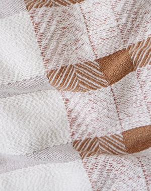 Närbild på Boho Tales filtens handvävda textur med geometriskt mönster i beige och terrakotta, 100% bomull