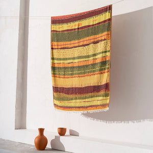 Gul-orange etnisk hammamhandduk med handvävt mönster hängande på vit vägg - lifestyle