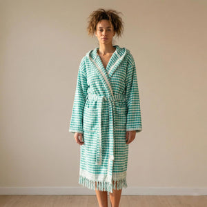 Kvinna i grön-vit morgonrock med pompomstruktur, bälte och fransar - helbild