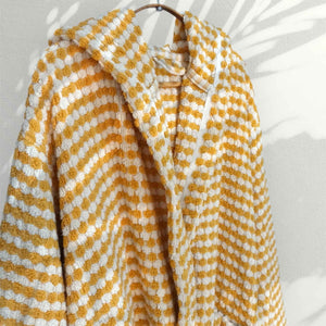 Gul randig morgonrock med pompomstruktur hängande - närbild på krage och mönster