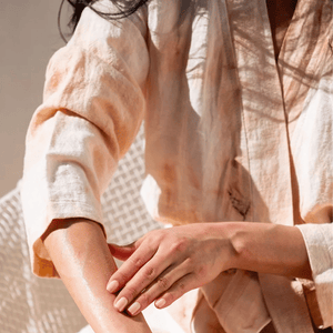 Närbild på Laranja kimonos linnetyg med batikinspierat mönster i solljus, lätt och luftig textur