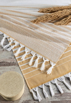 Paradiso frottéhandduk i ekologisk bomull gul med randigt mönster - lifestyle flatlay