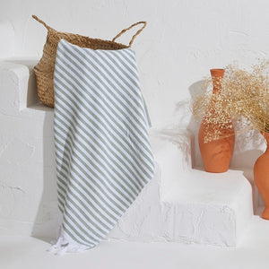 Scandi handduk i gröna och vita ränder hängande i ljus miljö