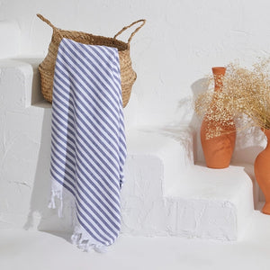 Scandi randig semifrotté handduk i navyblå ränder hängande i en somrig miljö