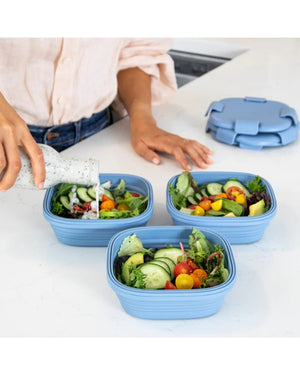 Tre Stojo hopfällbara matlådor fyllda med sallad – perfekt för måltider hemma och på språng