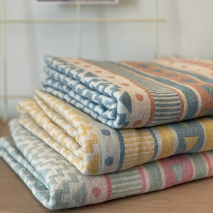 Lovely hamamhandduk i ekologisk bomull, staplade i aprikos, gul och rosa med medelhavsinspirerad design